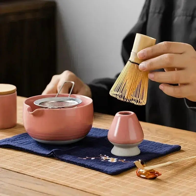 9-Piece Matcha Set - Premium Ceramic Bowl, Bamboo Whisk with tea pot and bamboo whisk on a table.