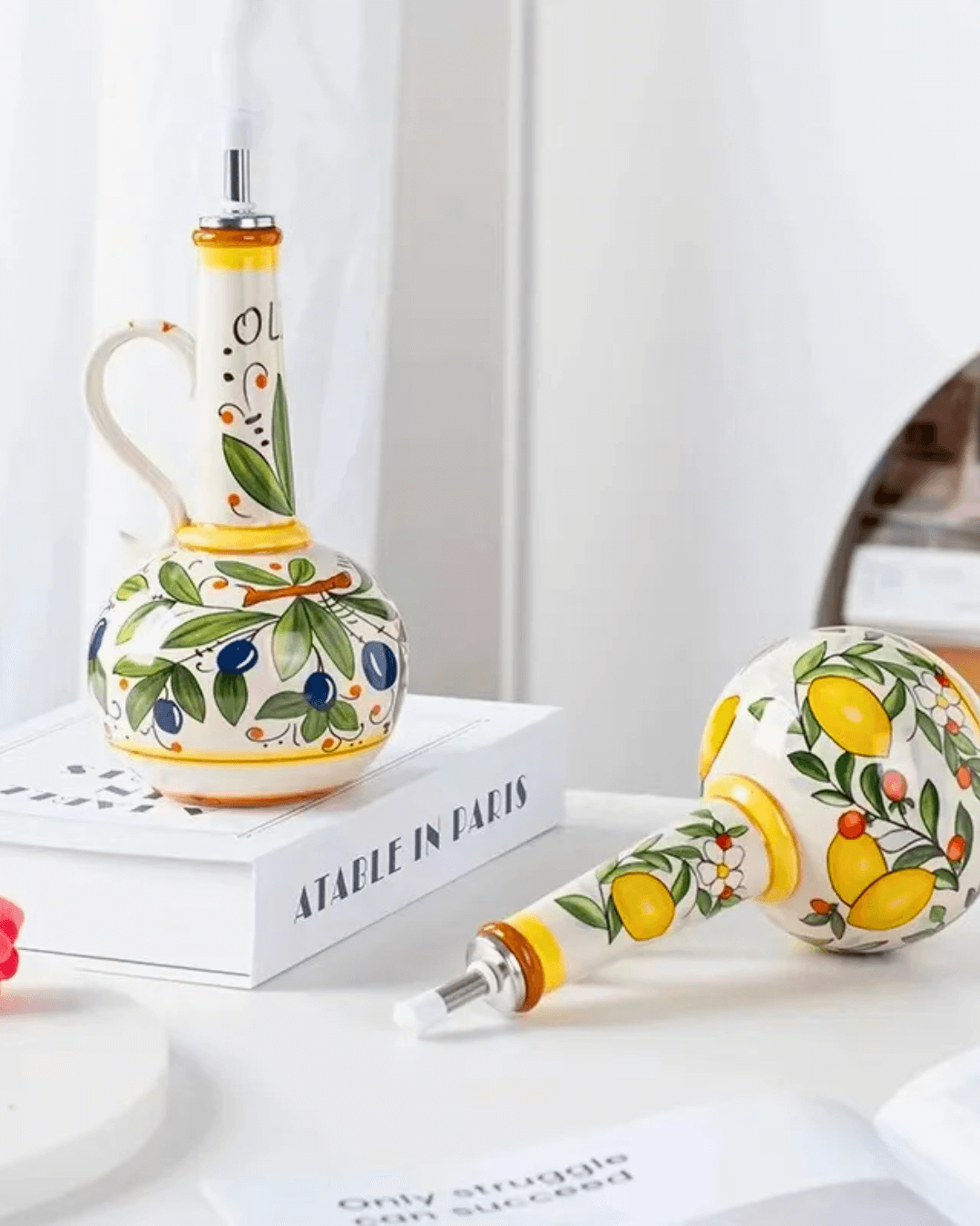 Hand-painted ceramic olive oil dispensers on a tabletop, featuring vibrant Mediterranean designs and leak-proof spouts.