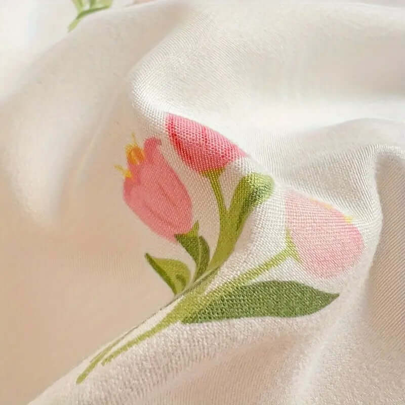 Close-up of floral cream duvet cover showcasing pink tulip design on lightweight microfibre fabric.