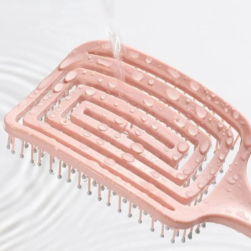 Detangling hair brush with hollow vent design, showcasing water droplets for easy cleaning and fast drying.