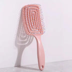 Detangling hair brush with hollow vent design in pink color, ideal for scalp massage and quick drying.