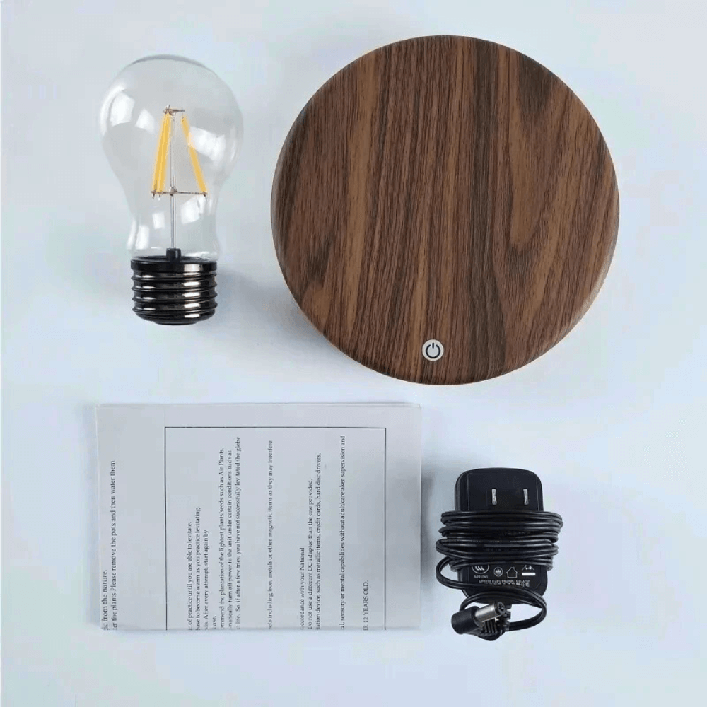 Levitating LED bulb with walnut base, power cord, and instructions for magnetic floating lamp.