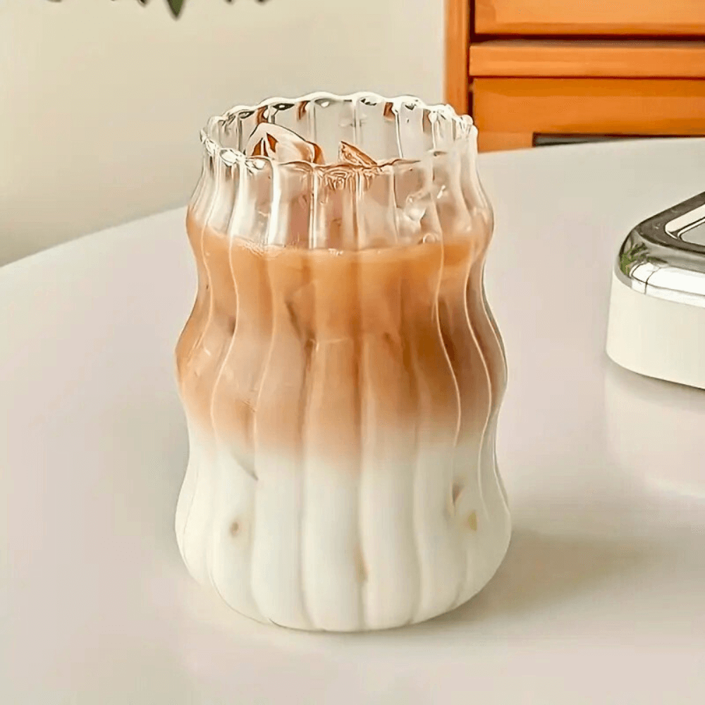 Heat-resistant 500ml matcha glass tumbler with iced latte, featuring a modern wavy design, perfect for drinks.