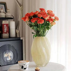 Elegant spiral glass flower vase showcasing vibrant orange roses as a stunning centerpiece.