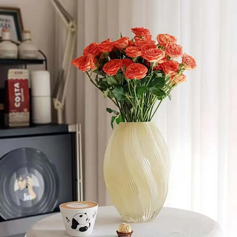 Elegant spiral glass flower vase showcasing vibrant orange roses as a stunning centerpiece.