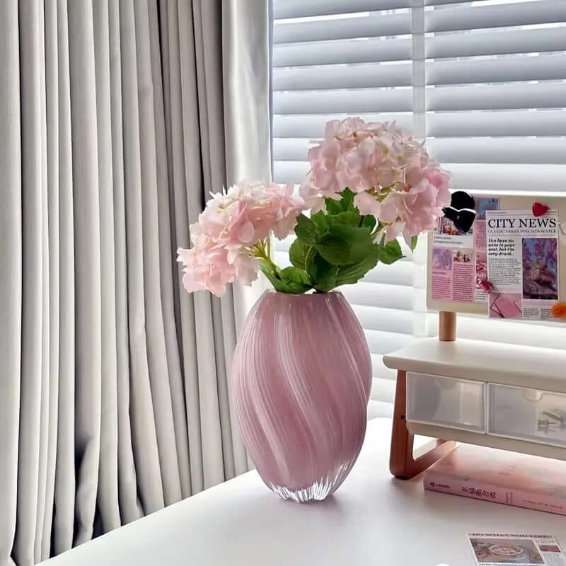 Elegant spiral pink glass flower vase with hydrangeas, perfect for modern home decor and centerpieces.