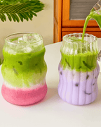 Two 500ml heat-resistant matcha glasses filled with layered iced drinks, showcasing vibrant green and purple colors.