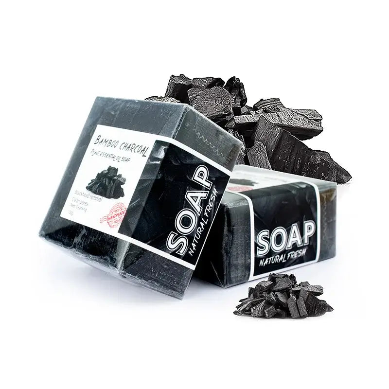 Bamboo charcoal soap bars stacked with charcoal pieces, perfect for deep cleansing and detoxifying skin.