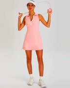 Model wearing a pink Padel tennis dress with built-in shorts, sleeve-free for optimal movement, holding a tennis racket.