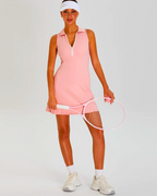 Model wearing pink Padel Tennis Dress with built-in shorts, holding a racquet, showcasing zip polo neck and A-line design.