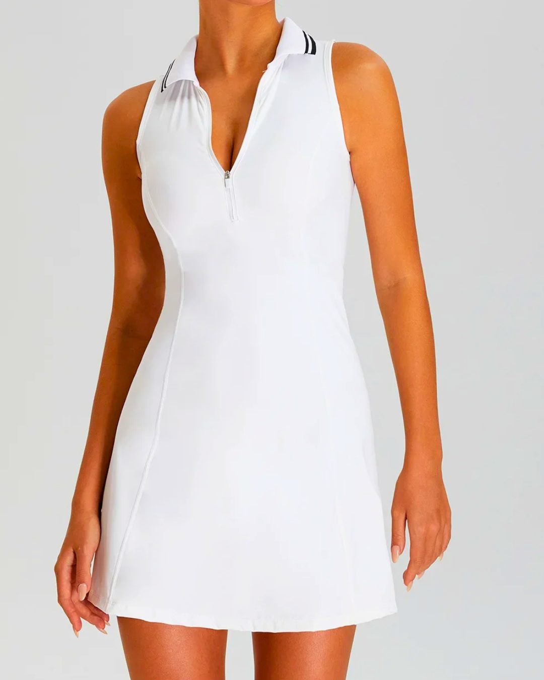 White padel tennis dress with zip polo neck and sleeveless design, featuring built-in shorts for secure coverage.