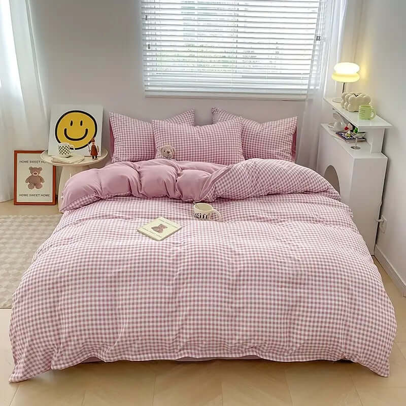 Cozy pink gingham bedding set in a bright bedroom, featuring a duvet, pillows, and soft textures.