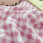 Close-up of soft pink gingham fabric for bedding with a cozy aesthetic, ideal for a stylish bedroom retreat.