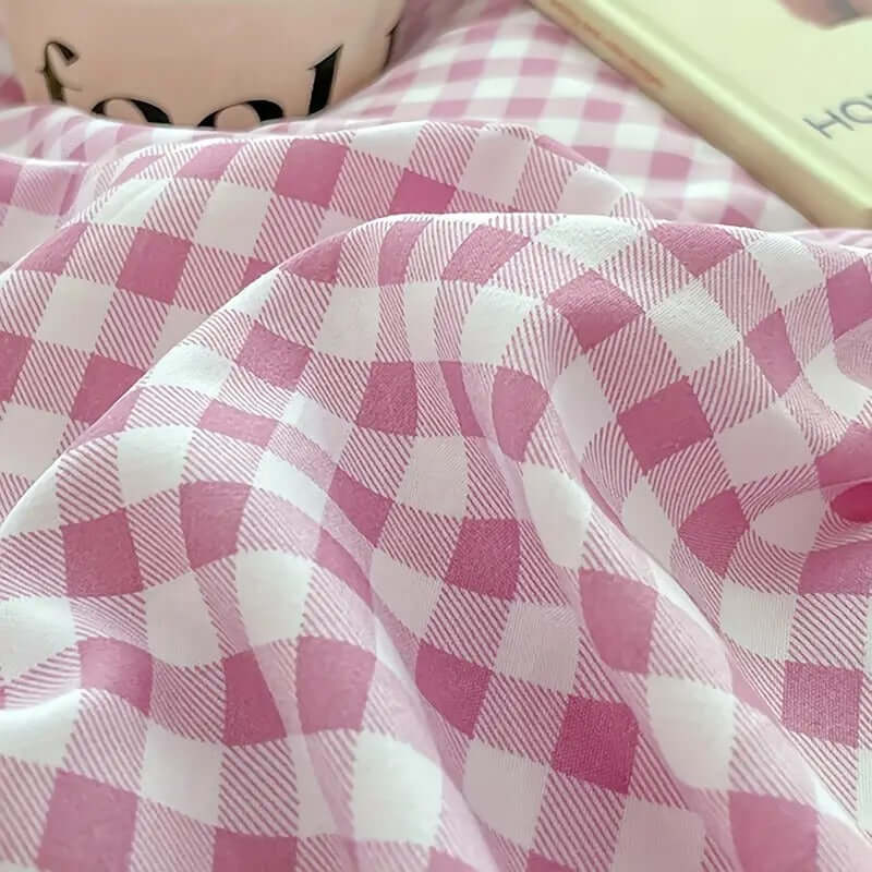 Close-up of soft pink gingham fabric for bedding with a cozy aesthetic, ideal for a stylish bedroom retreat.