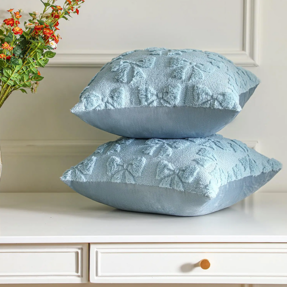 Plush quilted blue bow cushion covers set of 2, styled on a table, perfect for home decor.
