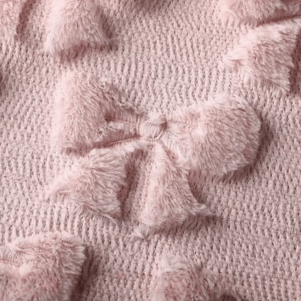 Soft quilted pink cushion cover texture featuring plush bow patterns, ideal for home decor.