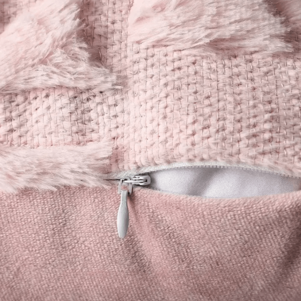 Close-up of plush cushion cover with zipper detail and soft pink texture, showing cozy fabric construction.