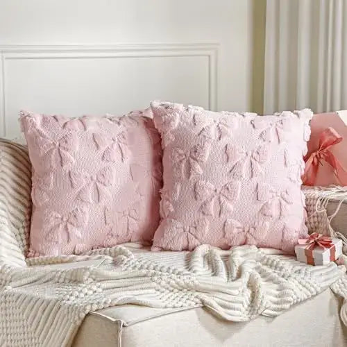 Plush quilted pink bow cushion covers on a cozy sofa with decorative throw and gift set.