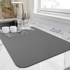 Quick-drying kitchen mat next to sink with dishes and utensils, ideal for keeping countertops dry and tidy.