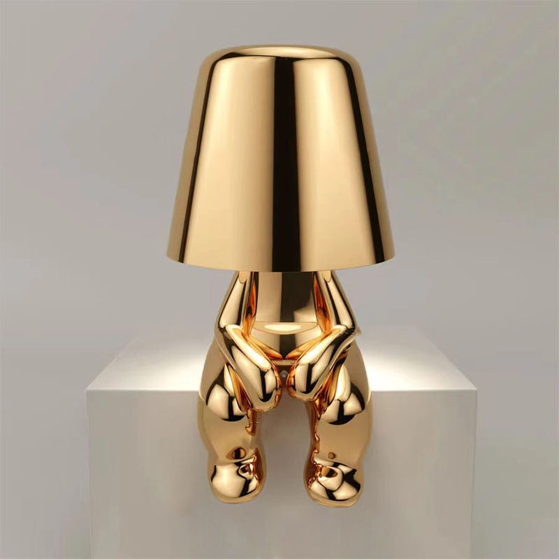 Gold LED figure lamp with a modern design and touch dimmer, perfect for creating a cozy atmosphere.