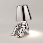 Stylish LED figure lamp with a chrome finish, featuring a cute sitting design and a touch dimmer for adjustable lighting.