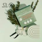 Volumizing solid conditioner with rosemary and biotin for fuller hair, surrounded by natural herbs and eco-friendly packaging.