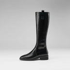 Women's knee-high black leather boots with a pointed toe and chunky heel.