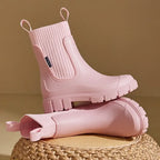 Pink waterproof Chelsea rain boots with ribbed elastic collar and slip-resistant sole.