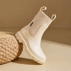 Cream Chelsea rain boots featuring a ribbed elastic collar and slip-resistant sole, perfect for wet weather.