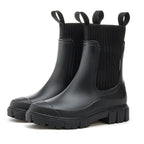 Black Chelsea rain boots with ribbed elastic band and slip-resistant sole for women, perfect for wet conditions.
