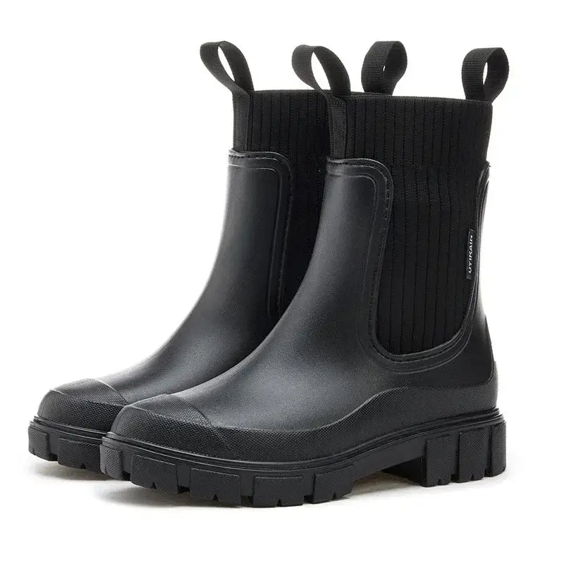 Black Chelsea rain boots with ribbed elastic band and slip-resistant sole for women, perfect for wet conditions.