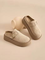 Women’s beige suede platform clog mules with buckle, perfect for casual outings and all-day comfort.