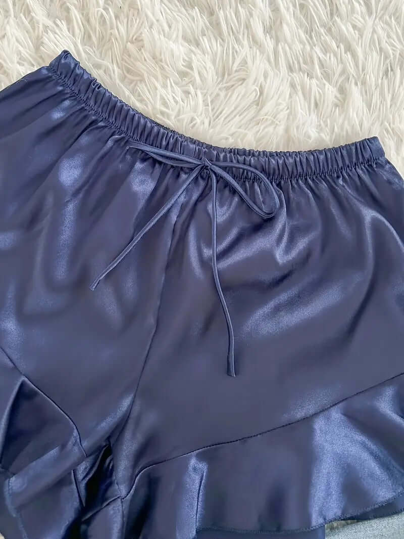 Close-up of navy satin shorts featuring an elastic waistband and drawstring for comfort in women's loungewear.