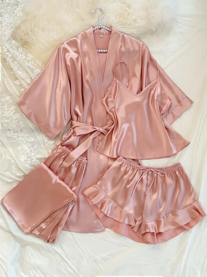 Women's satin pajama set in soft pink, featuring a robe, cami, shorts, and trousers, perfect for lounging and sleep.