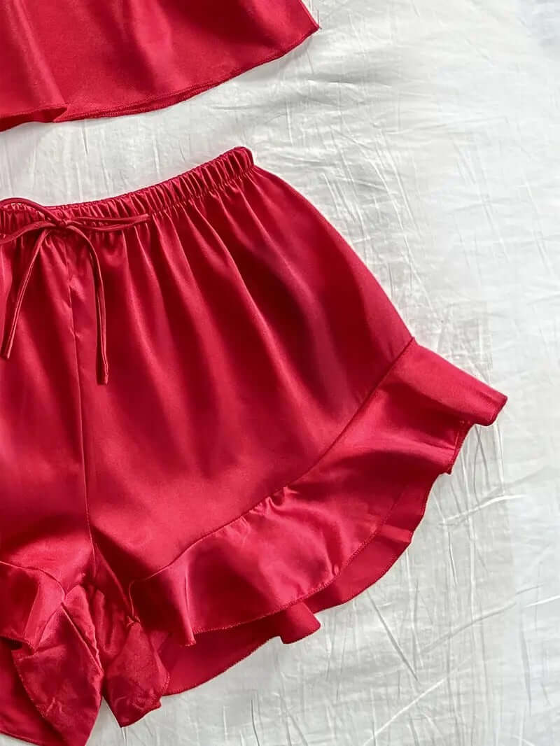Women's satin shorts with ruffle hem in vibrant red, part of a 4-piece lounge set.