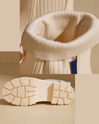 Close-up of beige Chelsea rain boots with ribbed collar and chunky slip-resistant sole.