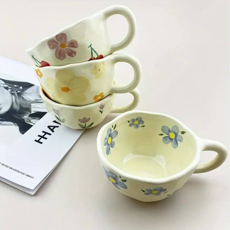 Flower pattern ceramic mug set stacked with floral designs on each cup against a magazine backdrop.